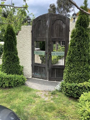 A wooden gate with signs reading "HOTEL" and "HAUMOANA" in front of a building.