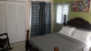 A bedroom with a bed, a wardrobe, and a chair. - Artscape Jamaica Villa @Richmond near Ocho Rios (Priory)