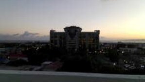 A high-rise building with a central tower, surrounded by other structures. - The Artist Place @ Kensington New Kingston (New Kingston)