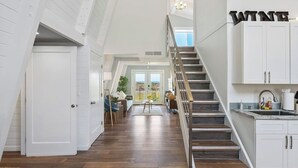 Un intérieur spacieux comprenant un escalier, un coin cuisine et un espace repas avec vue.