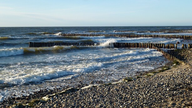 A rocky beach with waves crashing against wooden groynes. - Apartment Hiddensee (Wiek)