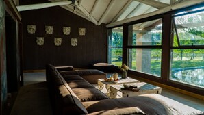 A modern living room with a large window, a sofa, a small table, and decorative wall art. - Casa Septem (Tunuyan)