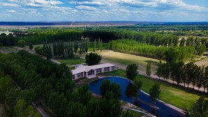 An aerial view of a property with a large building, a swimming pool, and surrounding greenery. - Casa Septem (Tunuyan)