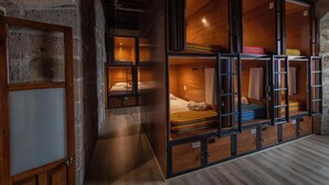 A room with bunk beds, wooden walls, and a stone wall. - OYO Hostal Mich Morelia (Morelia)