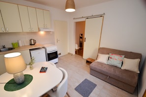 A compact living space with a kitchenette, a dining area, and a sofa. - Apartments Tea Kotor (Kotor)