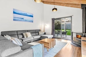 A modern living room with a grey sectional sofa, a wooden coffee table, and a fireplace.