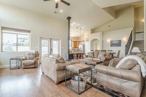 A spacious living room with multiple sofas, a coffee table, and a television in the background. - Black Bear IV: 2 King Suites & Dog-Friendly (Fruita)