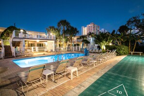 A swimming pool with lounge chairs and a shuffleboard court. - One block from Pompano Beach - condo w/ shared heated pool & sundeck (Pompano Beach)