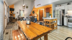 A spacious kitchen with a wooden dining table, a refrigerator, and a stove. - Welcome to “Stealing Time” – Your Cozy Getaway (Burnside)
