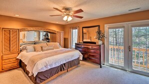 Un dormitorio con cama, cómoda y una ventana grande con vistas.
