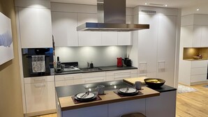 A modern kitchen with a central island, stainless steel appliances, and a minimalist design. - SnowKaya Appartement/Fewo 5-Bettwohnung by Interhome (Engelberg)