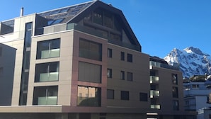 A multi-story building with a modern architectural design, featuring large windows and a sloped roof. - SnowKaya Appartement/Fewo 5-Bettwohnung by Interhome (Engelberg)