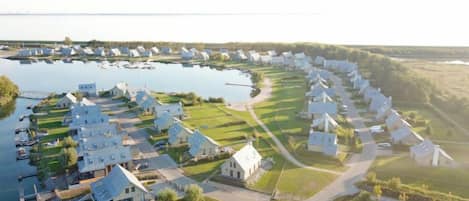 Een woongebied met huizen die in een halve cirkel zijn gerangschikt rond een centraal gelegen waterpartij.
