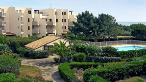 A residential building with multiple balconies, a swimming pool, and lush greenery. - Les Frégates by Interhome (Saint Cyprien)