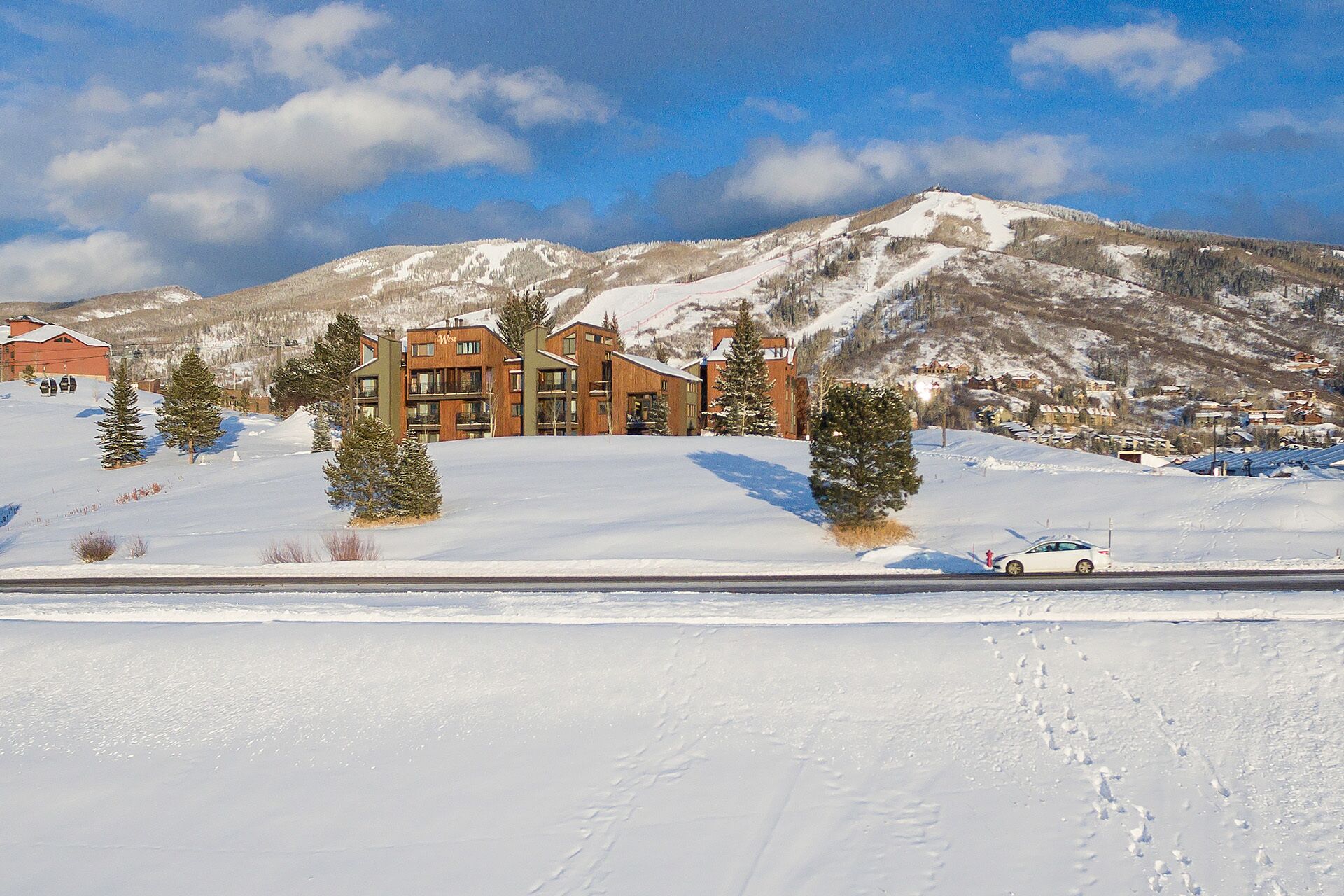 Un hôtel à l’architecture moderne, situé sur une pente enneigée avec une vue imprenable sur les montagnes.