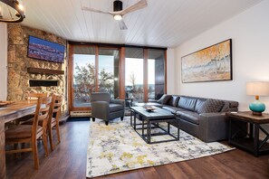 Relax in this stylish living room with a sofa, armchairs, and a flat-screen TV.