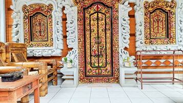 A traditional interior with ornate doors and a wooden table with chairs.