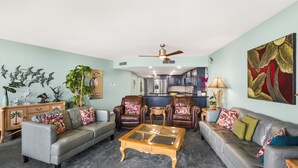 Ein Wohnzimmer mit zwei Sofas, einem Couchtisch und einem Deckenventilator.