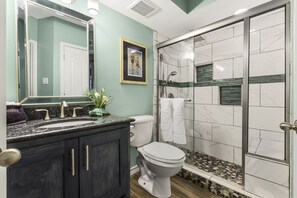 A bathroom with a vanity, sink, mirror, toilet, and shower area. - Sea Gull #210: Beachfront 3 bed 2.5 Bathroom With Spectacular Views and 24 Hour Management (Port Aransas)