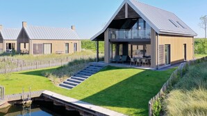 A modern house with a large balcony, a staircase leading to the entrance, and a small pool in the foreground. - Oesterdam Resort by Interhome (Tholen)