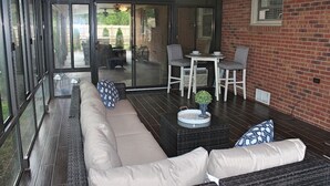 A covered patio with a sofa, chairs, and a table. - Beautiful Rustic Murfreesboro Home just minutes from I24, MTSU and more (Murfreesboro)