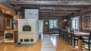 Een rustiek interieur met een open haard, een houten eettafel en stoelen.