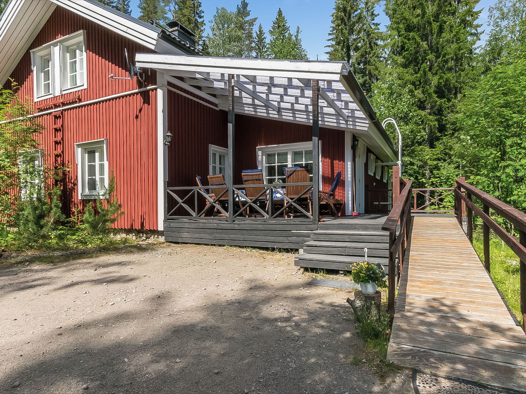 Punainen puinen rakennus, jossa on kuisti ja puinen terassi, joka johtaa siihen.