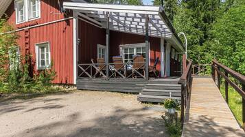 Punainen puinen rakennus, jossa on kuisti ja puinen terassi, joka johtaa siihen.