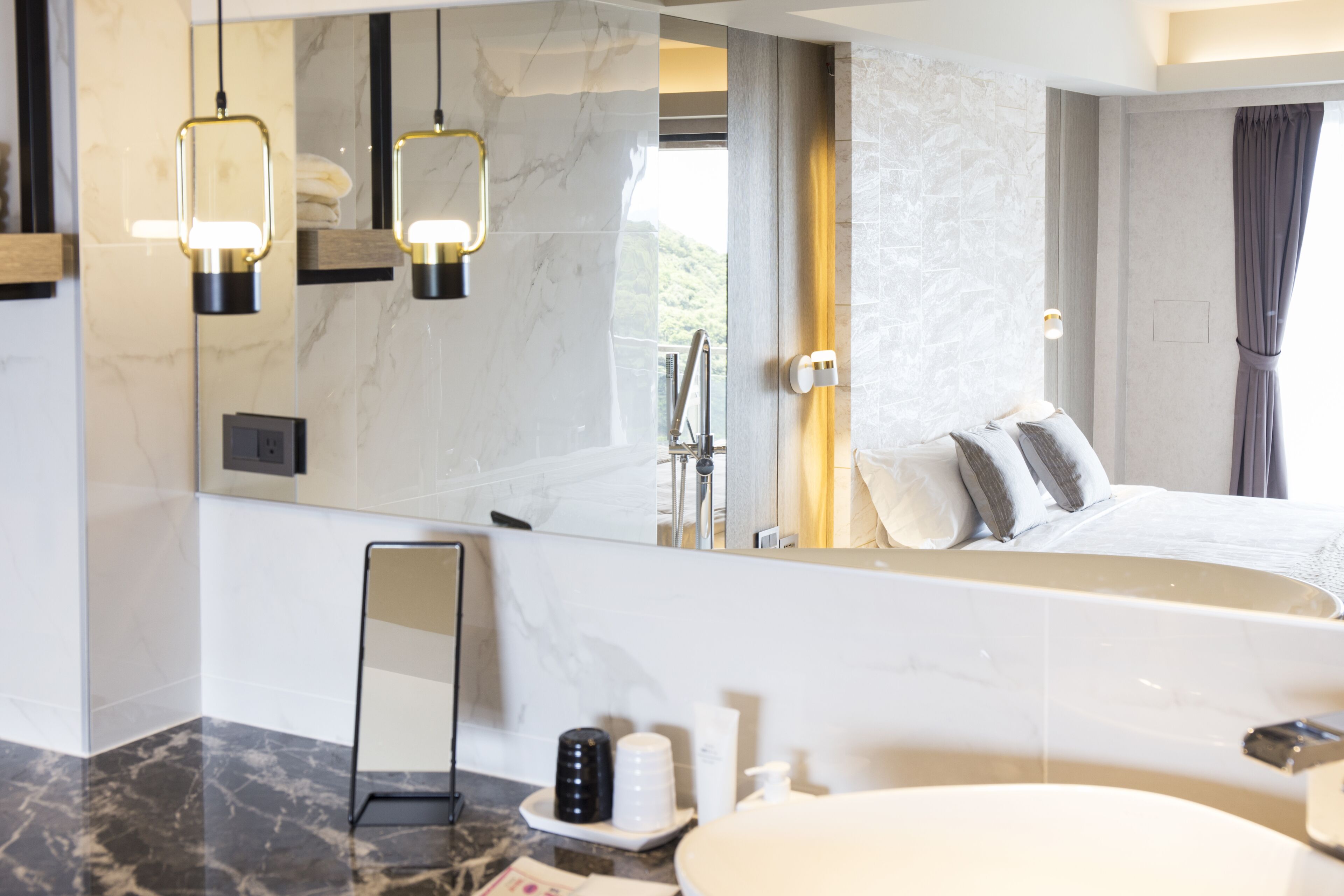 A modern bathroom with a large mirror, a bathtub, and a sink.