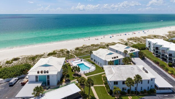 A beachfront hotel with multiple buildings, a swimming pool, and a view of the ocean. -   ⚓5400 Gulf Dr! 55+ condo with amazing pool just steps away from the beach!⚓🏖 (Holmes Beach)