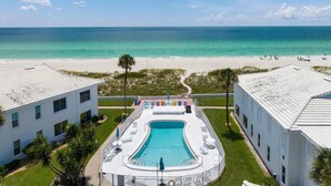 A pool area with a view of the beach and ocean. - ⚓5400 Gulf Dr! 55+ condo with amazing pool just steps away from the beach!⚓🏖 (Holmes Beach)