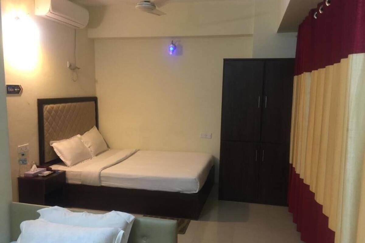 Ein Hotelzimmer mit Bett, Nachttisch und Kleiderschrank.
