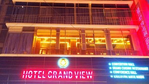 A hotel with a sign reading "HOTEL GRAND VIEW" and a list of amenities including a conference hall, grand cuisine restaurant, conference hall, and executive suite room. - Hotel Grand View (Sylhet)