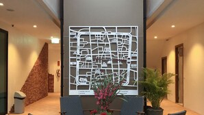 A lobby with a map mural, seating area, and a staircase. - Nine Hotel Chiangmai (Chiang Mai)