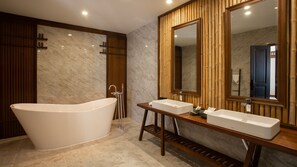 Bathroom features a bathtub, double sink vanity, and a large mirror.