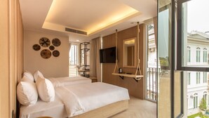 A bedroom with a large bed, a TV, a hanging chair, and a view of a building through the window. - Nine Hotel Chiangmai (Chiang Mai)