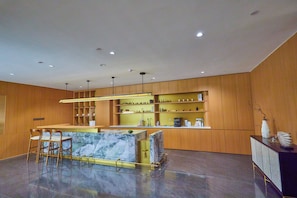 A modern kitchen with wooden cabinets, a marble island, and bar stools. - Holiday Inn Express Litang by IHG (Garze)