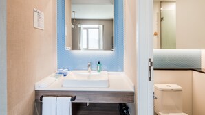 Ein Badezimmer mit Waschbecken, Spiegel und Toilette.