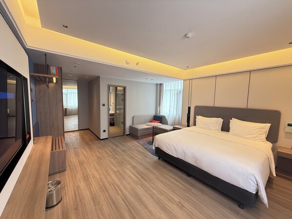 A modern hotel room with a large bed, a TV, a desk, and a seating area. - Holiday Inn Express Litang by IHG (Garze)
