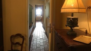 A hallway with a lamp, a chair, and a radiator. - Casa Legnaia, Tuscan Retreat in Castiglion Fiorentino (Castiglion Fiorentino)