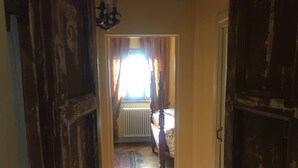 A hallway leading to a bedroom with a bed, a radiator, and curtains. - Casa Legnaia, Tuscan Retreat in Castiglion Fiorentino (Castiglion Fiorentino)