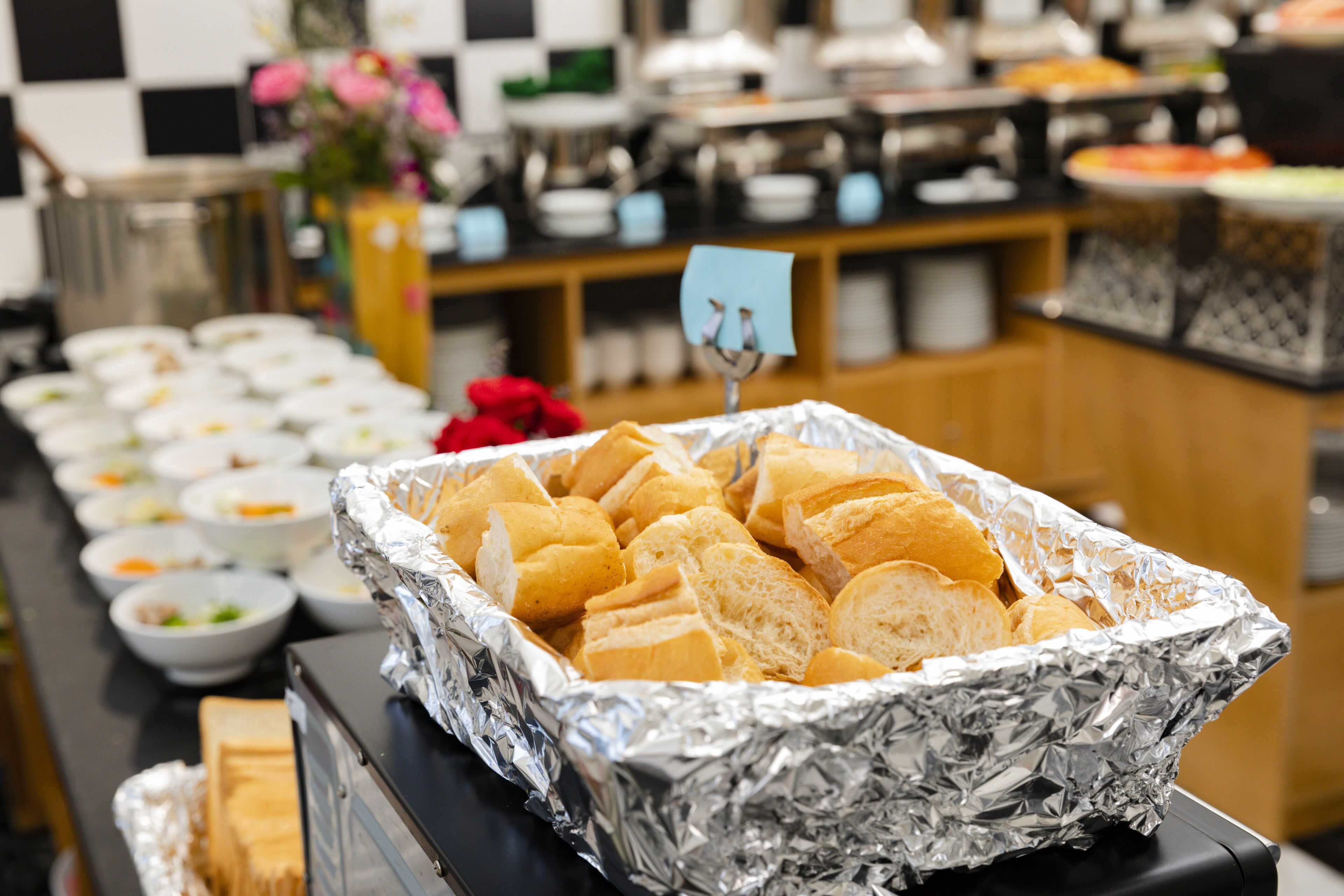 A buffet with various food items and a sign indicating a section.