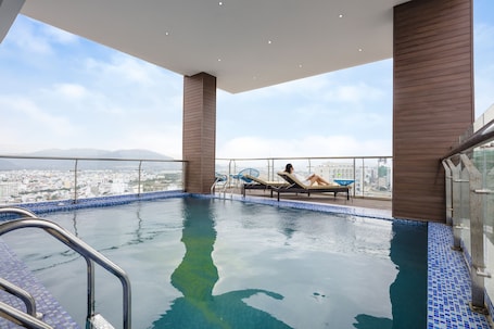 Una piscina al aire libre, sillones reclinables de piscina