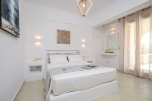 A neatly arranged bedroom with a large bed, bedside tables, a wall-mounted artwork, and a ceiling light fixture.