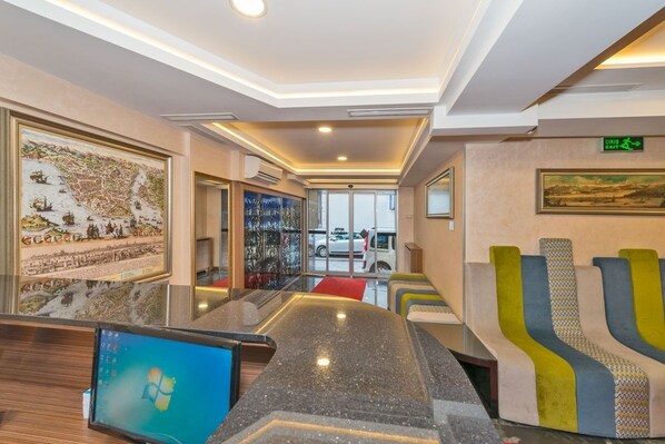 A modern lobby with a reception desk, a large map on the wall, and a staircase leading to the upper floors. - Floransa City Hotel (Istanbul)