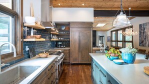 A modern kitchen with wooden cabinets, a central island, and a large window providing natural light. - Lake View Home with Private Hot Tub (Tahoma)