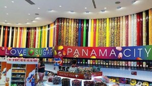 A colorful candy store with a curved ceiling and a variety of sweets displayed on shelves.