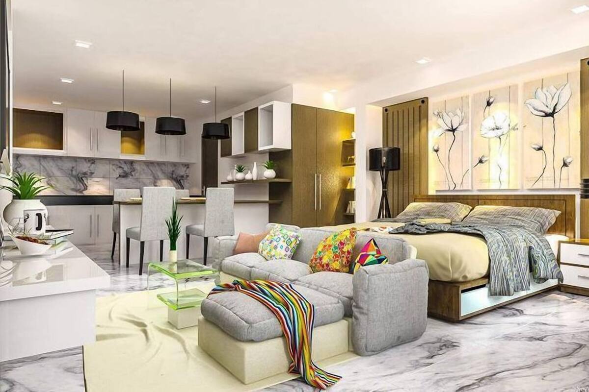 A modern living room with a sofa, ottoman, and a dining area with chairs.