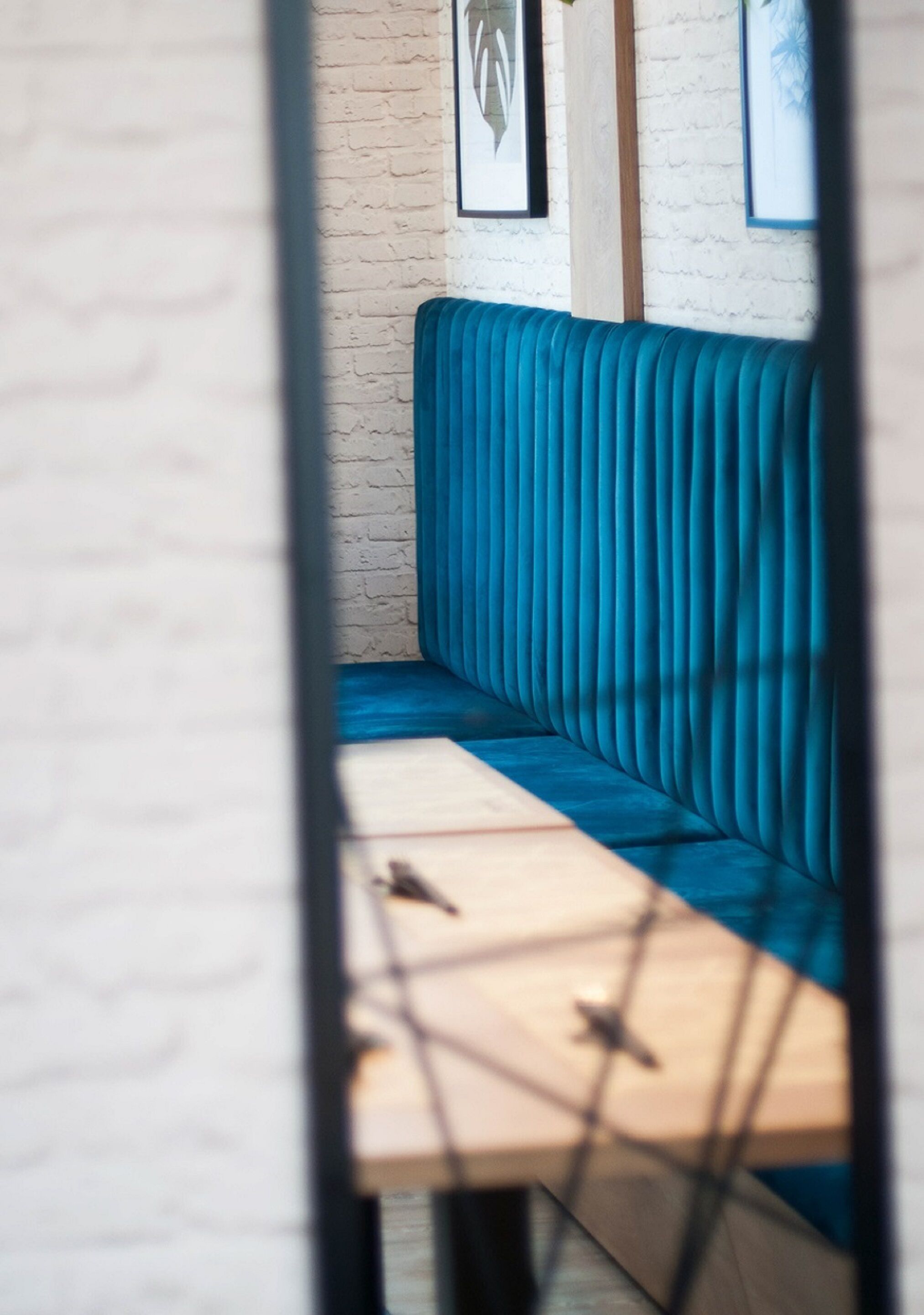 A blue upholstered bench with a wooden table in front.