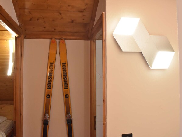 A wooden ceiling and a pair of yellow skis leaning against a wall.